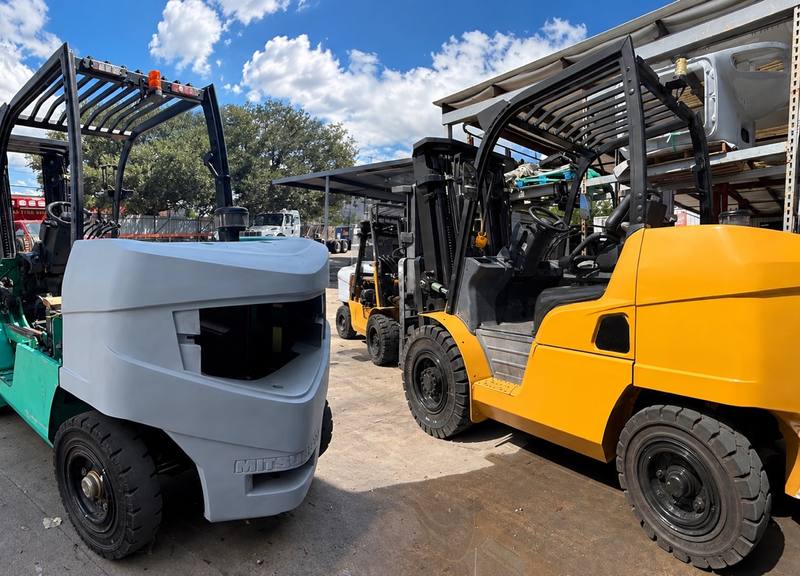 Forklifts at the First Class Auto yard, one in primer and one finished in yellow