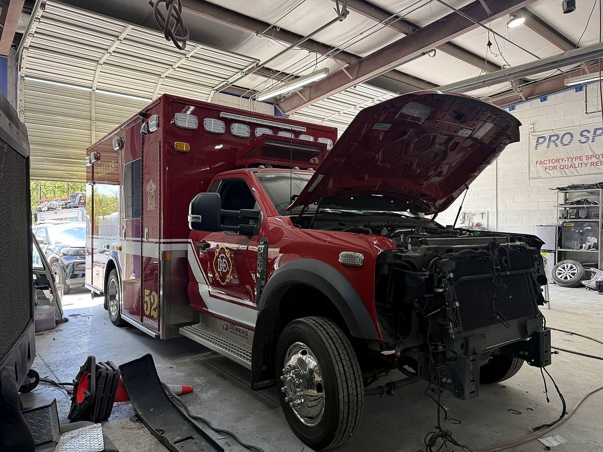 Emergency ambulance with the front end disassembled during major repair in a First Class Auto service bay