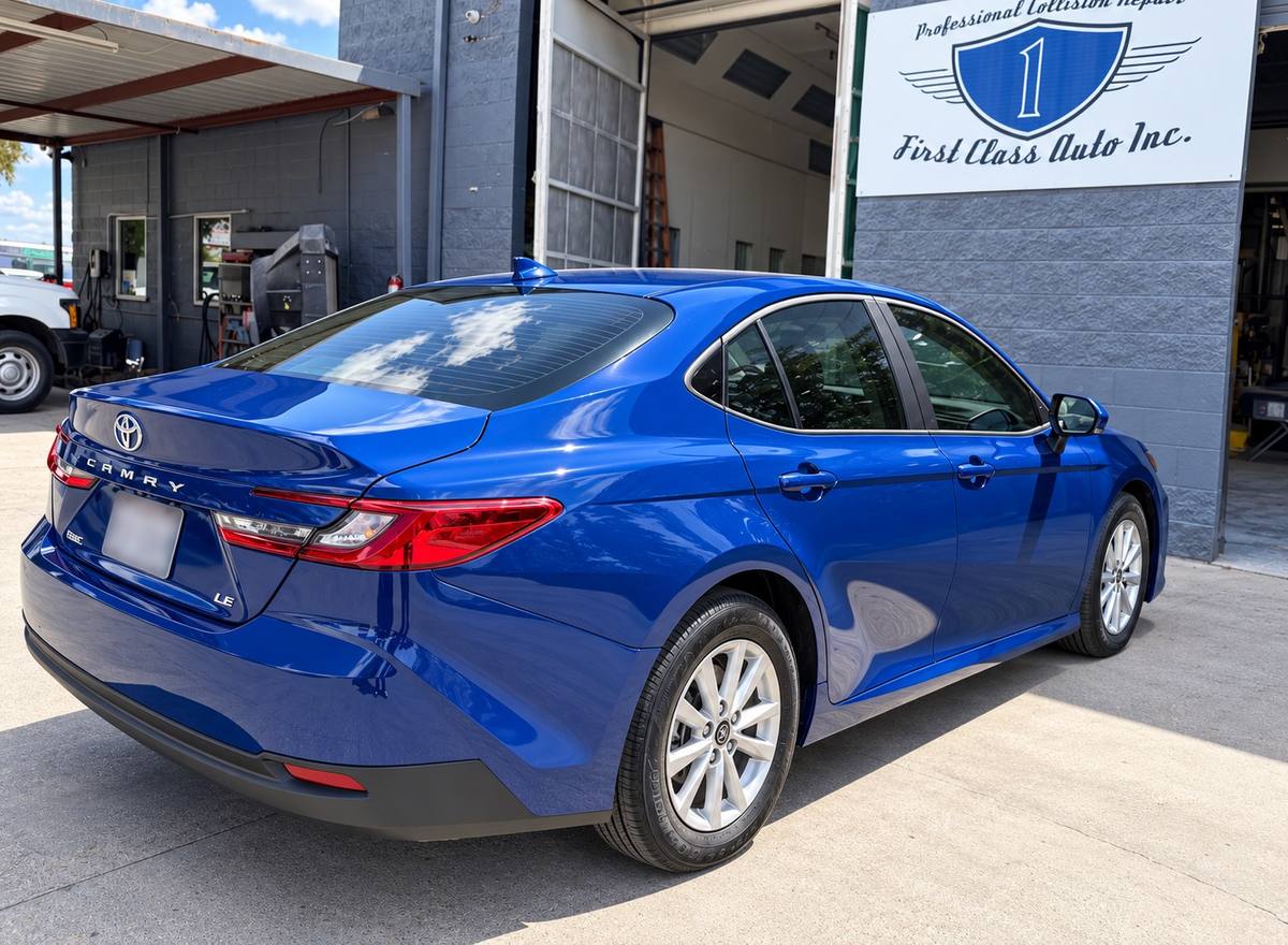Blue Toyota Camry after completed collision repair, parked outside the First Class Auto Inc. facility