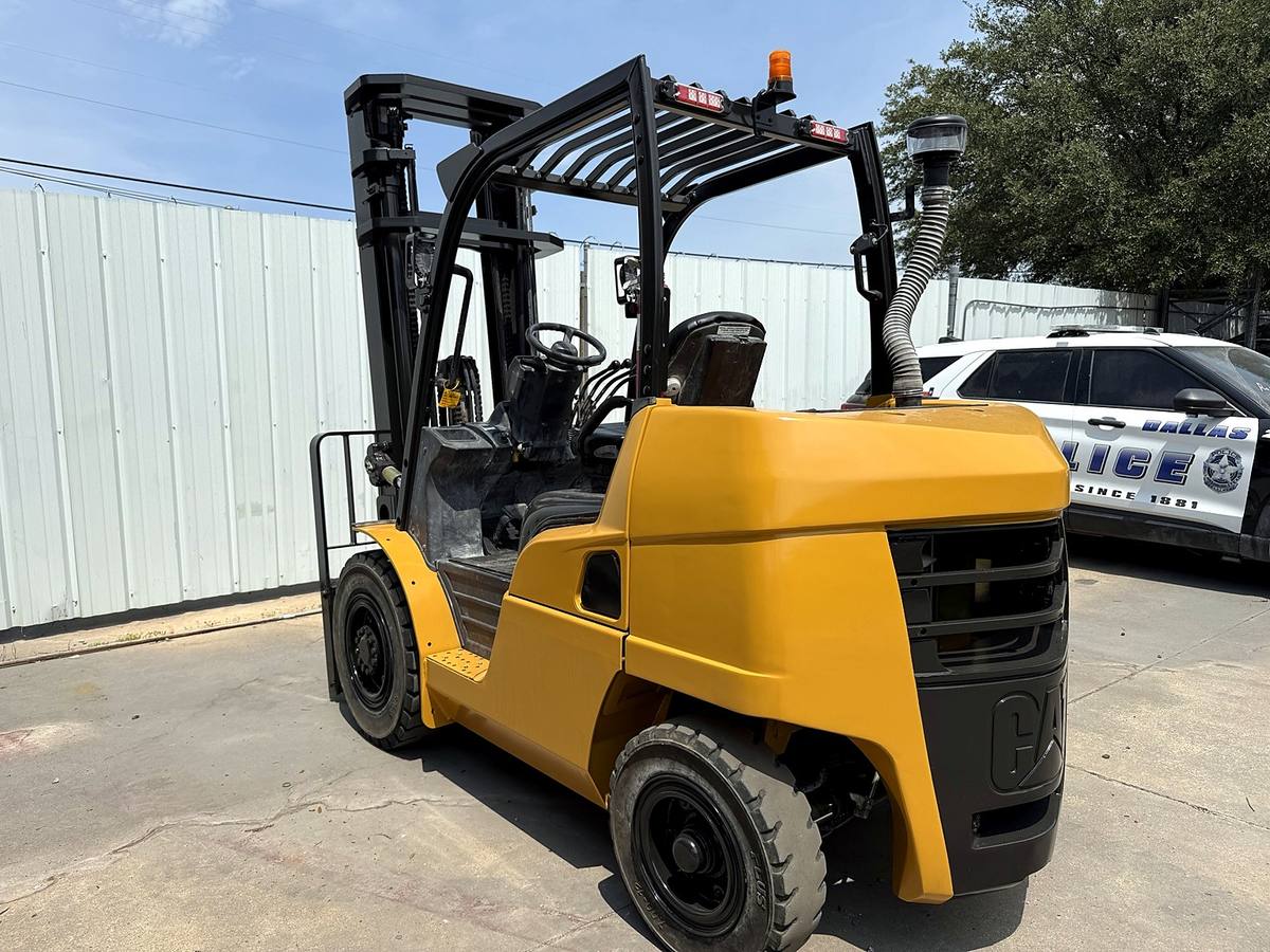 The same forklift after stripping, repair and refinishing in yellow, parked outside the facility
