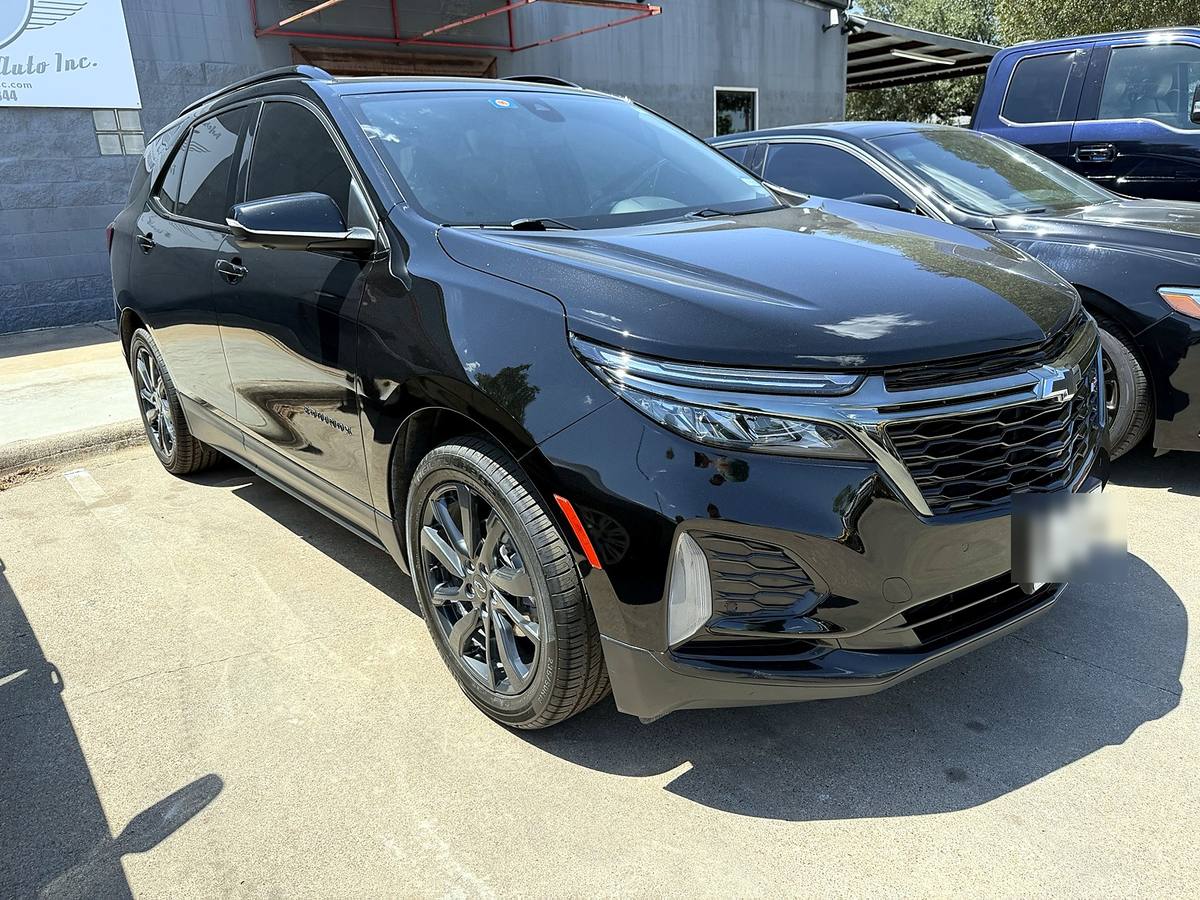 Completed black Chevrolet Equinox after collision repair, three-quarter front view
